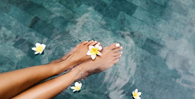 Feet dipped in a serene freshwater pool, creating a relaxing and refreshing experience.